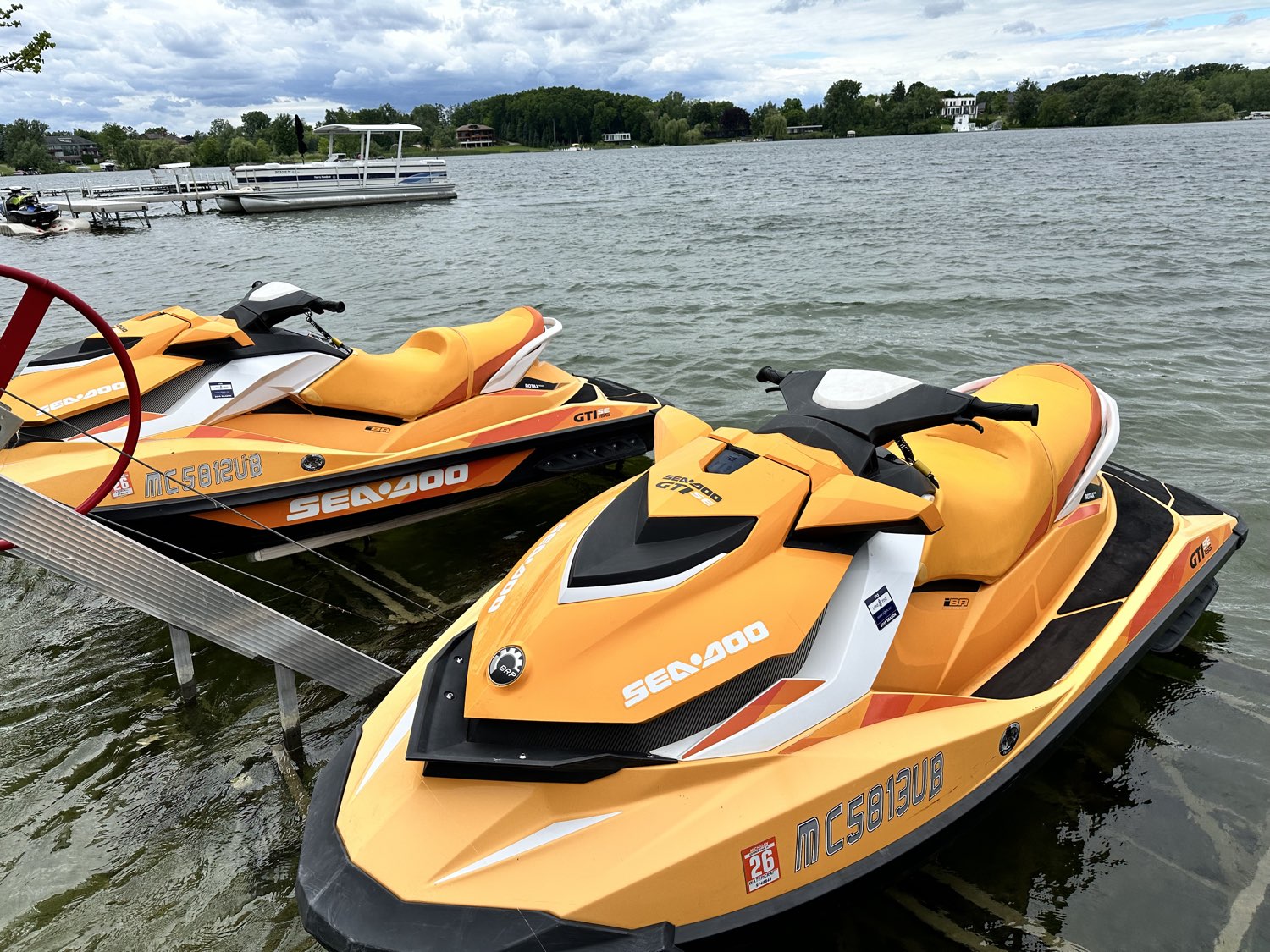 Two clean Sea-Doo jet skis on the lake